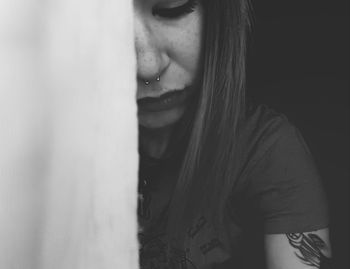 Close-up of young woman leaning on wall