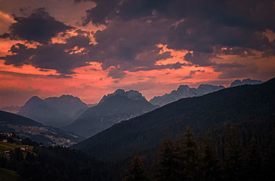 Scenic view of mountains against dramatic sky during sunset