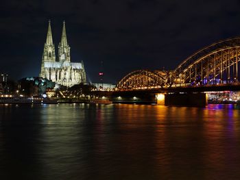 Illuminated bridge over river at night