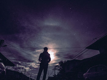 Silhouette man standing against sky at night