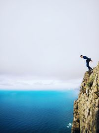 Man paragliding over sea against sky