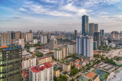 Aerial view of buildings in city against sky