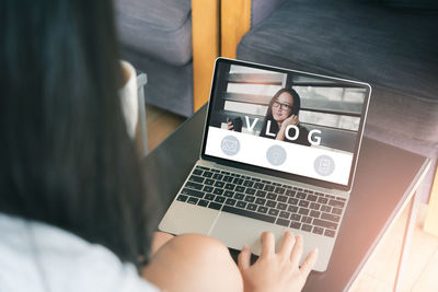 Rear view of woman using laptop in office