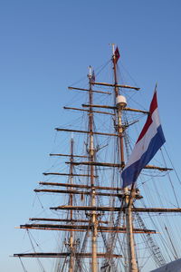 Low angle view of sailboat against clear blue sky