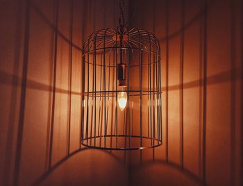 Close-up of illuminated light bulb hanging on wall