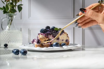 Cropped hand of woman cutting a slice of cake