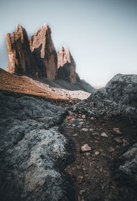 Rock formations on shore against sky