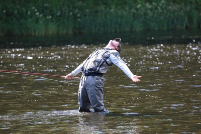 Side view of man fishing in river