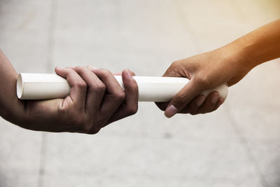 Close-up of hands holding rolled paper