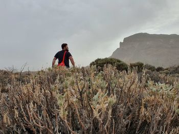 Man standing on land against sky