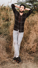 Portrait of young man standing on field