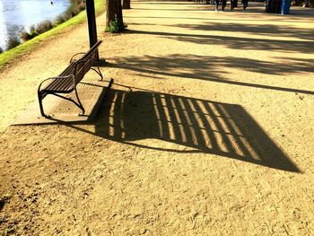 High angle view of empty park bench on sunny day