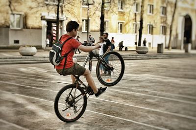 Man riding bicycle on street in city