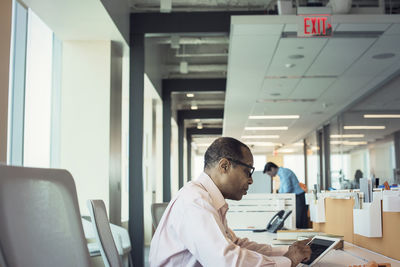 Businessman working alone in office using digital tablet