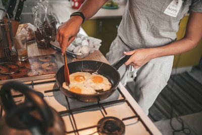 Midsection of man preparing food in kitchen at home