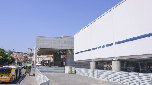 Street amidst buildings against clear blue sky