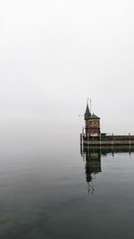 Building by lake against sky