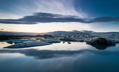 Scenic view of snowcapped mountains against sky during sunset