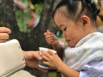 Close-up of girl eating food outdoors