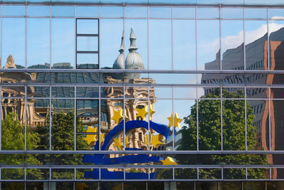 Metal fence by building against sky