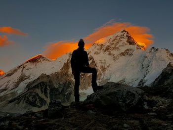 Man standing on snowcapped mountain against sky