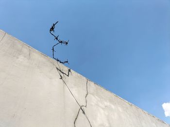 Barbed wire over a high fence against the sky