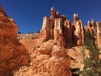 Low angle view of rock formation against clear blue sky