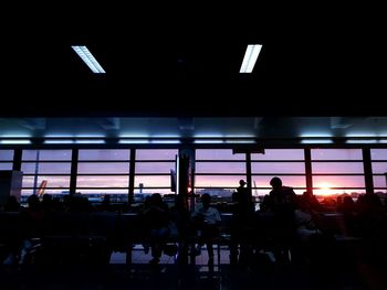 Silhouette people sitting in illuminated room