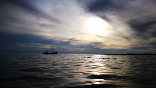 Ship sailing on sea against sky during sunset