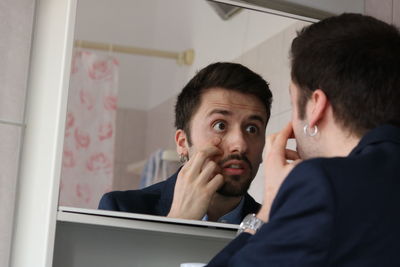 Portrait of young man with reflection on window