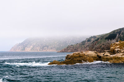 Scenic view of sea and mountains against sky