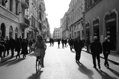 People walking on road along buildings