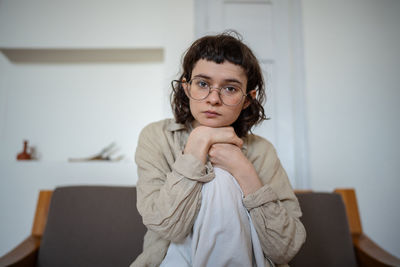 Portrait of young woman sitting at home