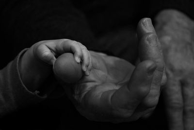 Cropped image of baby holding father hand