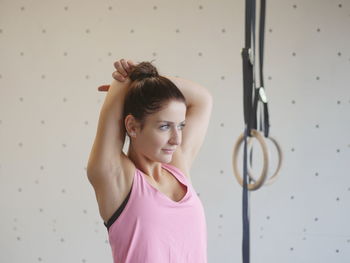Young woman exercising by gymnastic rings
