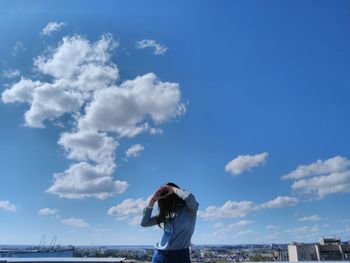 Woman standing against blue sky