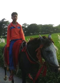 Young woman with horse on field against sky