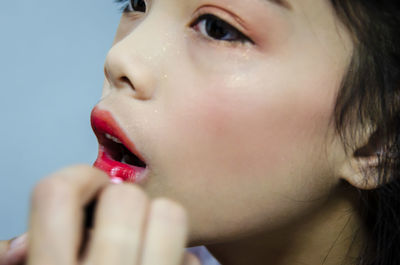 Close-up of girl applying lipstick