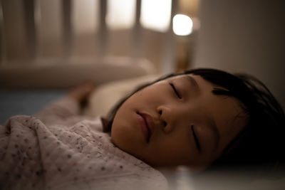 Close-up of baby sleeping on bed