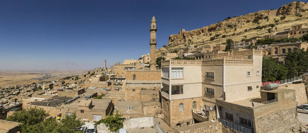 Buildings in town against clear blue sky