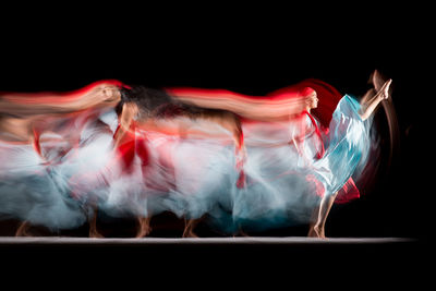 Digital composite image of women dancing against black background