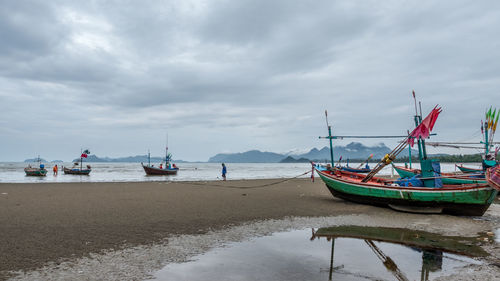 Fishing boats moored on sea against sky