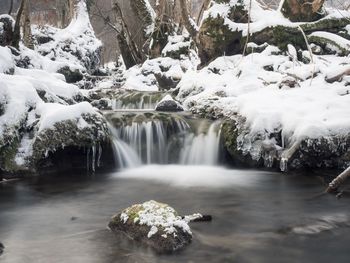 Scenic view of waterfall in forest during winter