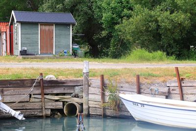 Boat moored by lake against building