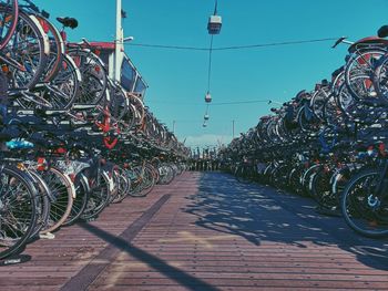 Bicycles parked on street in city against sky