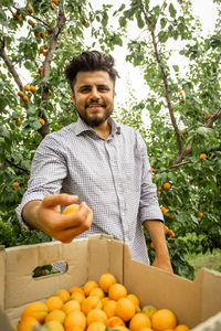 Portrait of man with fruits on tree