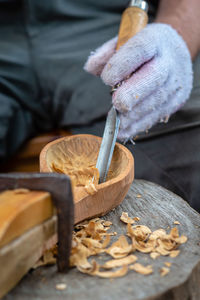 Midsection of man carving wood