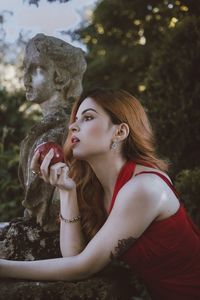 Young woman with eyes closed against trees