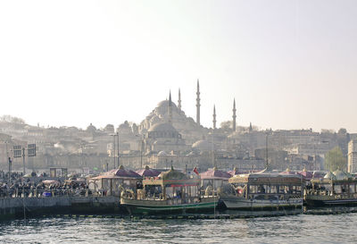 Boats at harbor with blue mosque in background