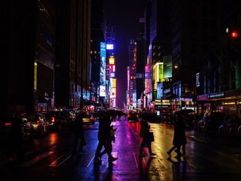 People walking on road in city at night